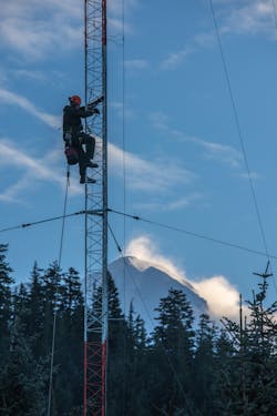 A worker climbs a radio tower to replace an electric light in Cordova, Alaska. A worker climbs a radio tower to replace an electric light in Cordova, Alaska.