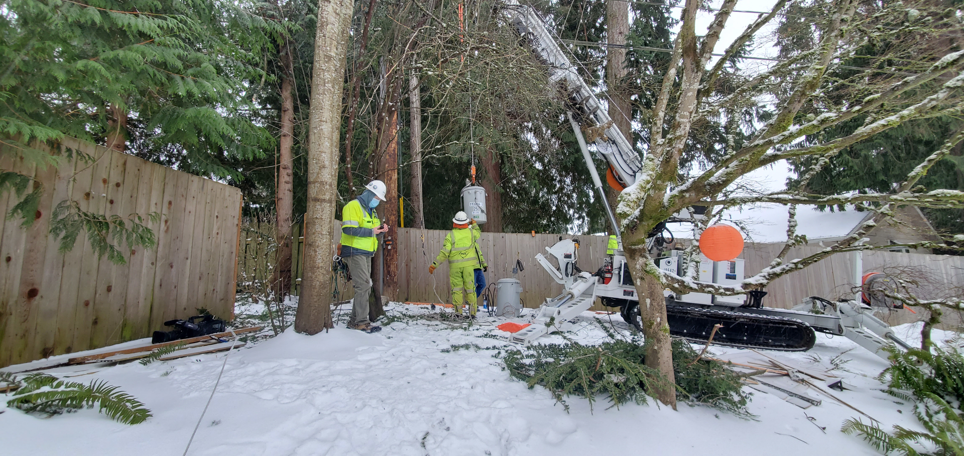 Line workers for Portland General Electric repair power distribution equipment damaged in SW Portland, Oregon.
