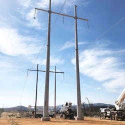 This shows the temporary wooden H-frame structures supporting the line next to the completed steel H-frame structures. The line had yet to be transferred to the new structures. This shows the temporary wooden H-frame structures supporting the line next to the completed steel H-frame structures. The line had yet to be transferred to the new structures.