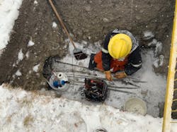 ENMAX worker repairs faulty cable during wintry conditions.