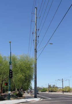 Existing pole with the 69 kV line, 12 kV line, communication cables and a street light attachment making for an upgrade problem.