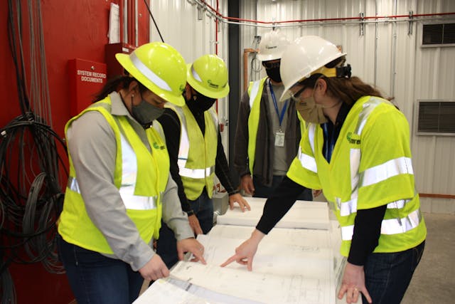 Inside the STATCOM, Project Manager, Suzanne Pohlman (left) and Emily C. McCurren, (right) Transmission Substation Design Engineer, review construction drawings with the project team.