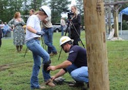 Braelyn Durbin of James Wood High School in Winchester puts on the gaffs to start her pole-climbing adventure. Braelyn Durbin of James Wood High School in Winchester puts on the gaffs to start her pole-climbing adventure.