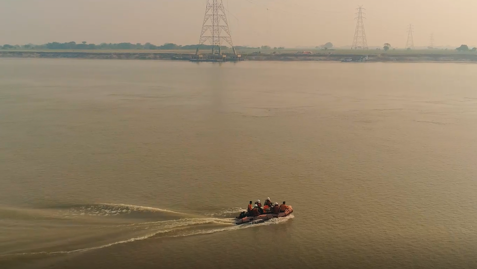 Overhead line crew crossing the River Ganges via inflatable dinghy.