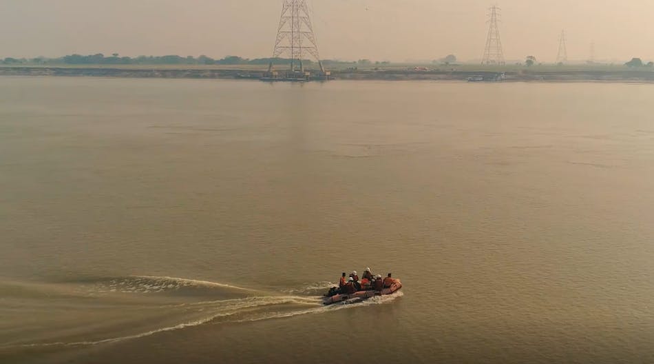 Overhead line crew crossing the River Ganges via inflatable dinghy.