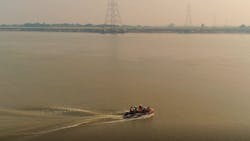 Overhead line crew crossing the River Ganges via inflatable dinghy. Overhead line crew crossing the River Ganges via inflatable dinghy.