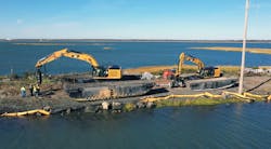 Moving heavy earthmoving equipment into position on the Grassy Sound Channel crossing. On the left, the larger excavator installs the piles (torque motor screws them in) and the smaller excavator will feed the pile sections to the install machine. Moving heavy earthmoving equipment into position on the Grassy Sound Channel crossing. On the left, the larger excavator installs the piles (torque motor screws them in) and the smaller excavator will feed the pile sections to the install machine.