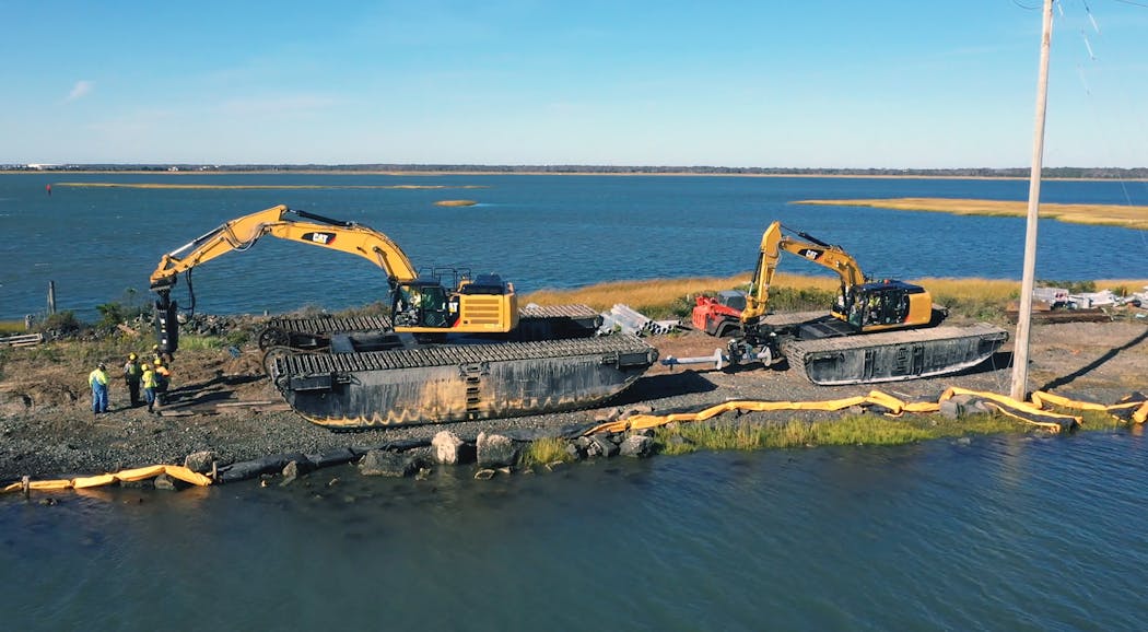 Moving heavy earthmoving equipment into position on the Grassy Sound Channel crossing. On the left, the larger excavator installs the piles (torque motor screws them in) and the smaller excavator will feed the pile sections to the install machine.