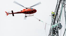 Statnett line worker installs 420-kV insulators aided by helicopter. Statnett line worker installs 420-kV insulators aided by helicopter.