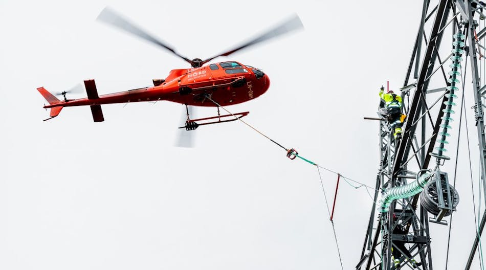 Statnett line worker installs 420-kV insulators aided by helicopter.