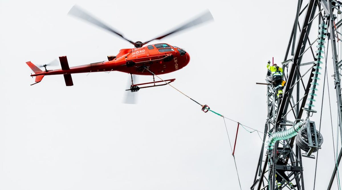 Statnett line worker installs 420-kV insulators aided by helicopter.