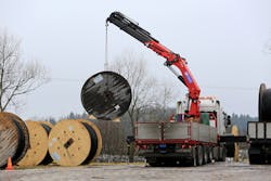 A cable truck unloads spools of power cable in Salo, Finland during an overhead to underground transmission project. Undergrounding lines is often touted as a way to cut down on outages due to severe weather.