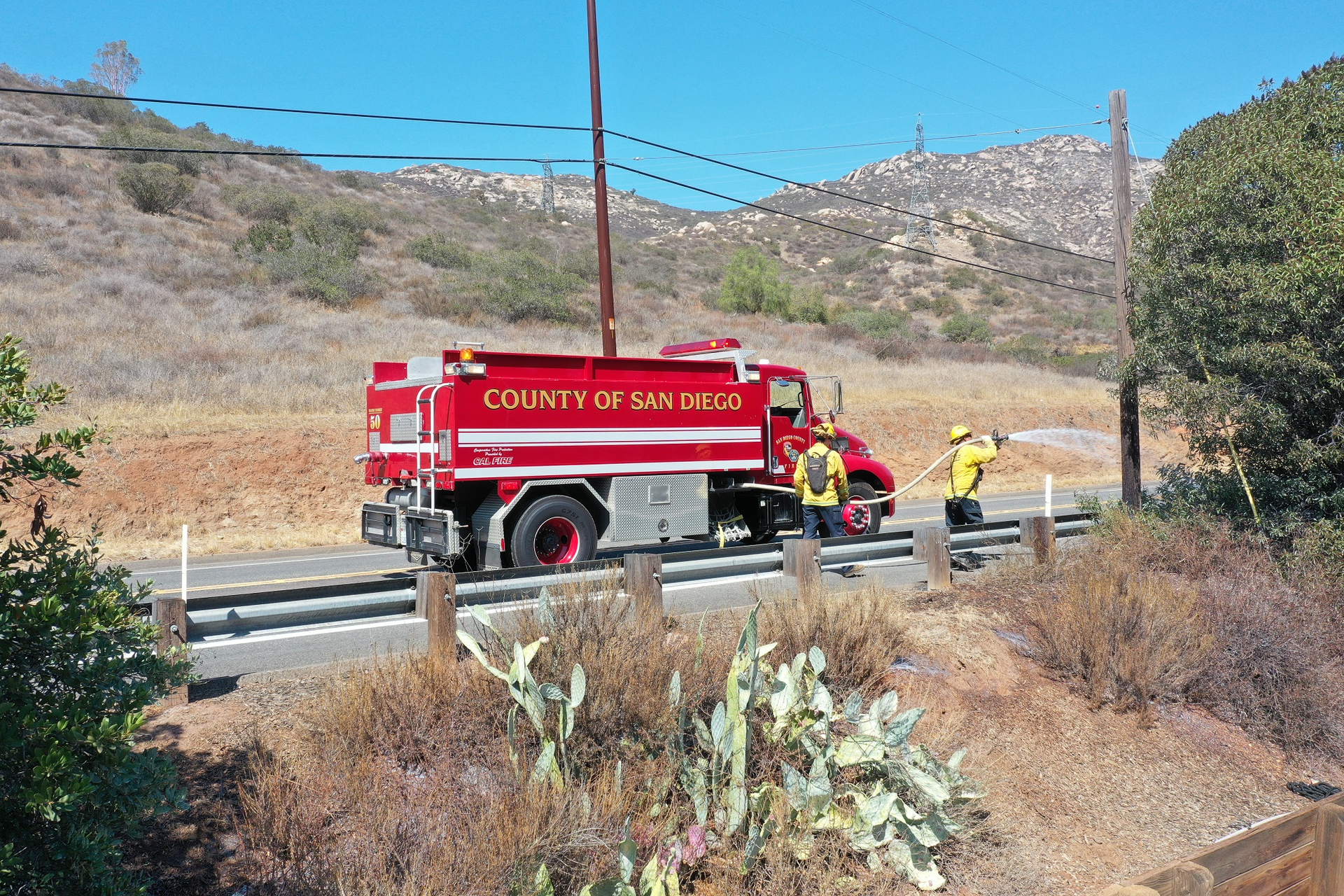 Firefighters apply long term fire retardant. California utilities were some of the first to deploy the technology.