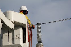 Linesman making-off a covered conductor to an insulator showing also, the spiral anti- vibration damper. Linesman making-off a covered conductor to an insulator showing also, the spiral anti- vibration damper.
