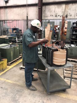 An Emerald Transformer technician works on a transformer component. Raw materials are blamed for the current shortage of transformers and their components.