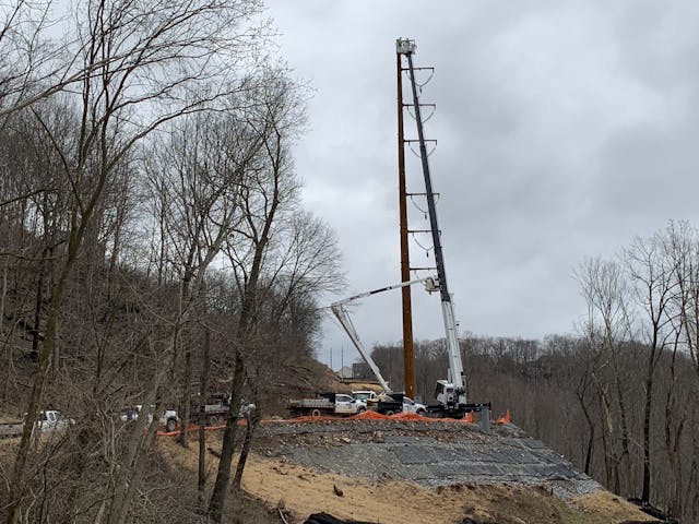 The lineworkers are erecting new weathered steel monopoles to replace century-old lattice steel towers.
