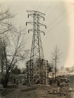 In the early days, lineworkers erected a lattice tower without the heavy equipment line crew have access to today.