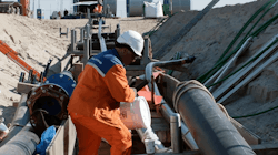 Workers service an underground electrical conduit. Workers service an underground electrical conduit.