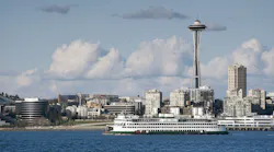 A ferryboat passes by the Seattle waterfront on the way to Bainbridge Island. The Space Needle can be seen in the background.