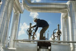 A worker adjusts valves at a California solar thermal power plant. A worker adjusts valves at a California solar thermal power plant.