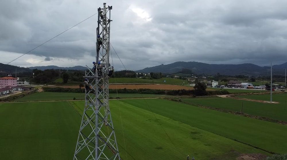 Steel lattice tower being assembled in the rural section of overhead line.