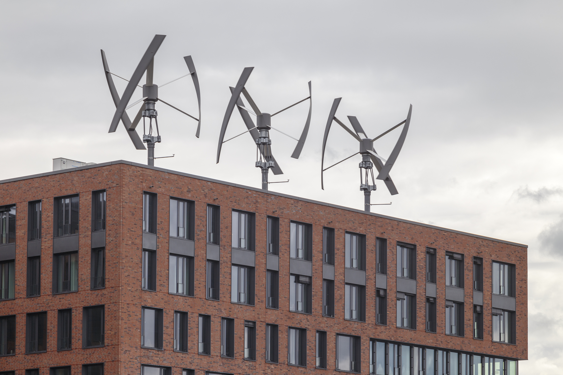Vertical axis wind turbines arrayed on a piece of commercial real estate in Germany.