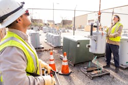 Line workers prepare for their next job by loading pole-mounted transformers onto trucks. Line workers prepare for their next job by loading pole-mounted transformers onto trucks.