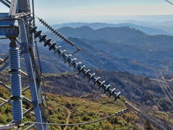 Metal transmission tower overlooks a fire scarred mountain. Metal transmission tower overlooks a fire scarred mountain.