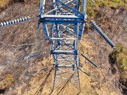 Overhead view of metal transmission tower surrounded by scorched earth.