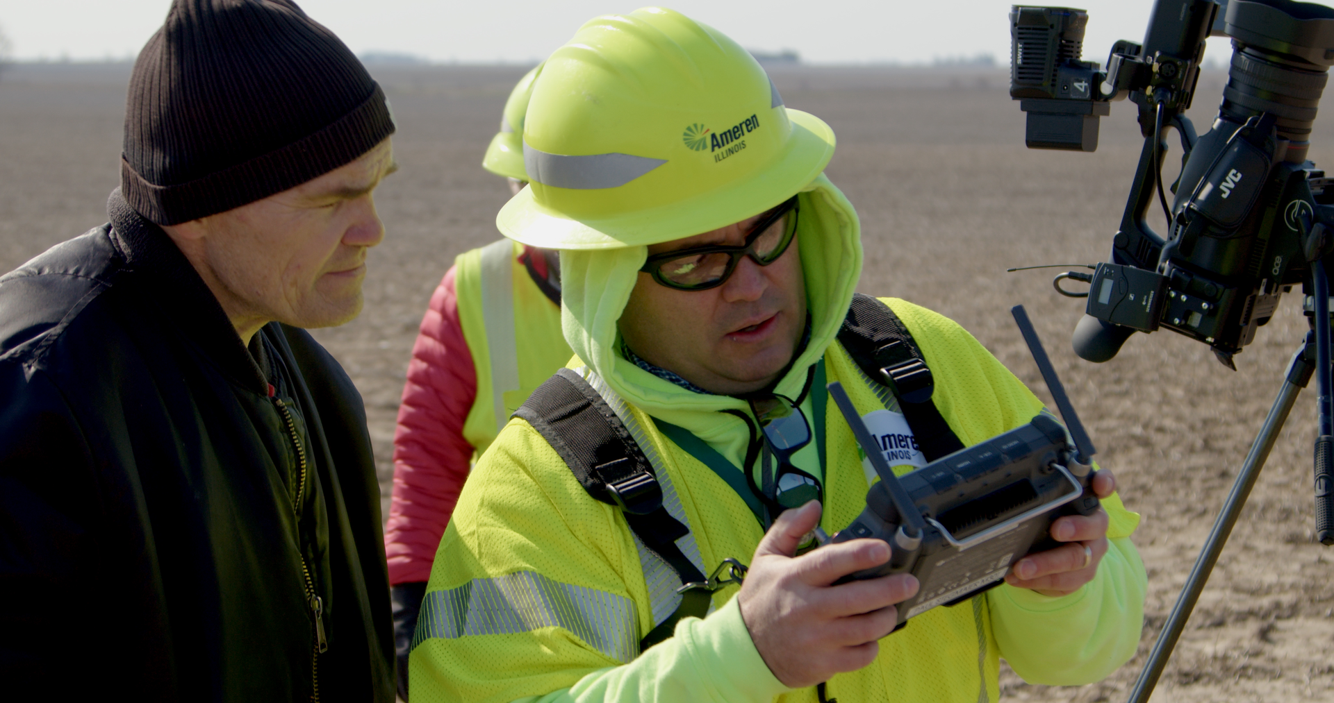 Mark Stacey, National Weather Service, looks over the shoulder of Ameren Illinois UAV-licensed drone pilot, Paul Stegmaier, as he flies a drone to assess the damage of a weather radio signal in Champaign County, Illinois. A recent storm damaged the device and left the weather service's radio signal offline.