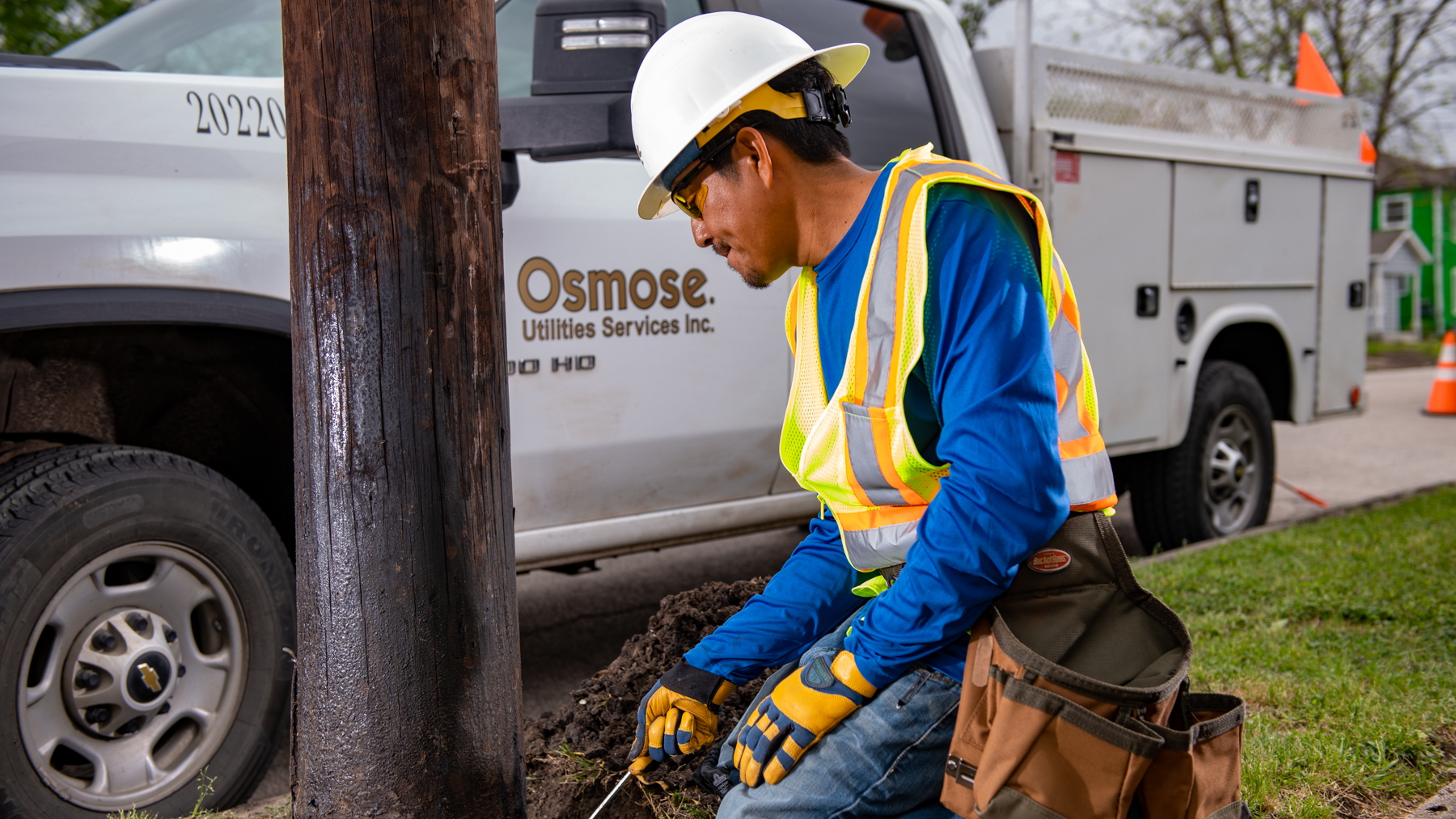 Performing a groundline inspection on a wood utility pole to detect decay.