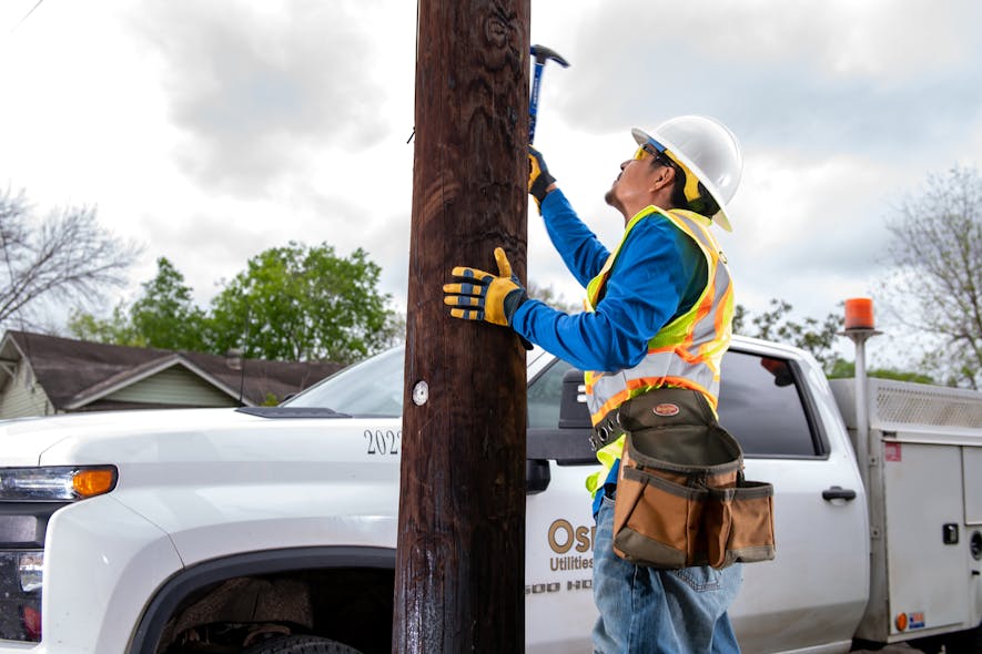 Performing a sounding inspection on a wood utility pole.