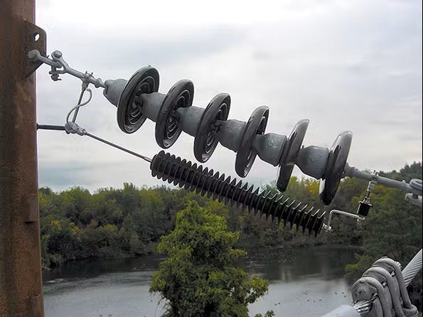 This is a detail of a lightning arrester installation at a structure with spacer cable on one side and bare conductor on the other.