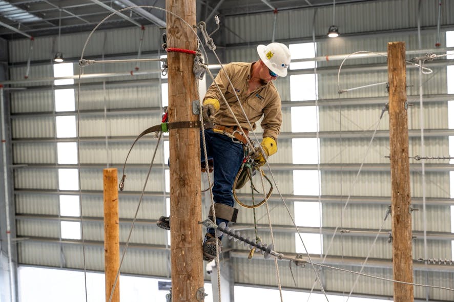 Apprentice Lineman Robert Sheely demonstrates how CenterPoint Energy trainees learn to build new electric line construction on wooden utility poles at the Hiram O. Clarke Training Center.