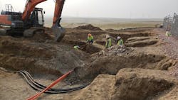 PacifiCorp crews work on underground cables near a functioning wind farm. PacifiCorp crews work on underground cables near a functioning wind farm.