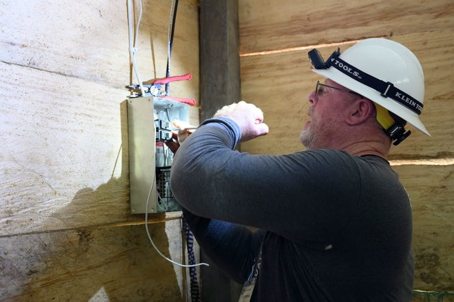 Larry Crowell, lineman with Cotton Electric Cooperative, installs electric panel in a rural home that is now equipped to receive electricity for the first time.