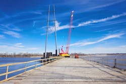 A temporary trestle provides a crane access to reinforce a transmission tower foundation in the Platte River.