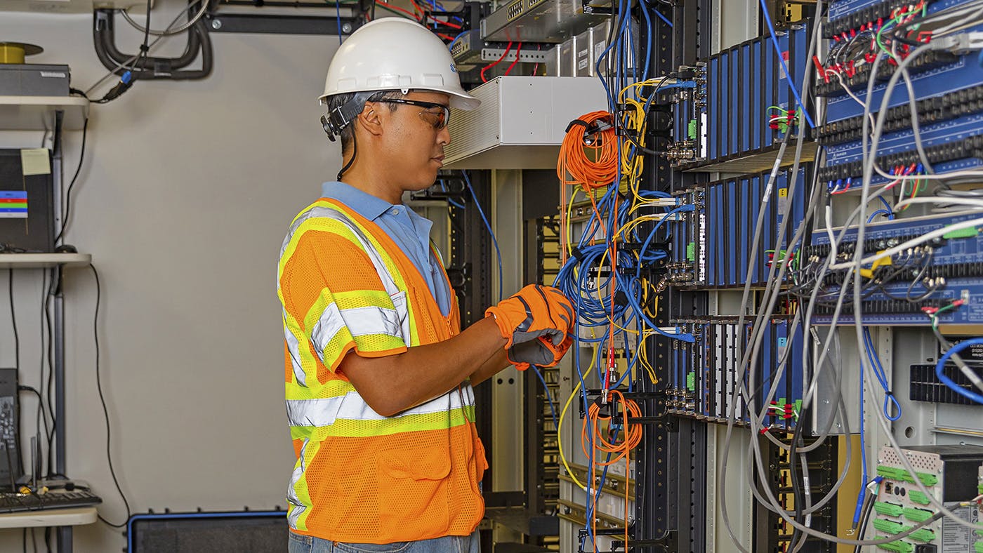 66144a96c67f0c001d421ae2 Newengineer Checking Wires In Lab