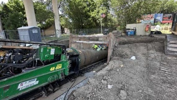 Crew members from Iowa Trenchless in Panora, Iowa, adding another section of casing together to continue rotating and pushing the auger flighting forwards.