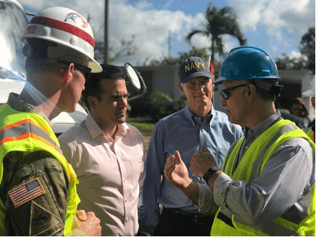 Consultant Carlos Torres (at far right) speaks to points of contact for the lead agencies restoring power in Puerto Rico after Hurricane Maria in 2017.