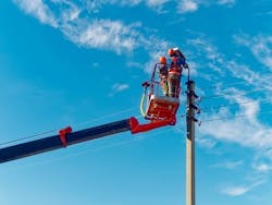 Two Electricians From The Cradle Of An Aerial Platform Or Crane Are Repairing A Street Lighting Lamp. Two Electricians From The Cradle Of An Aerial Platform Or Crane Are Repairing A Street Lighting Lamp.