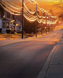 Utility worker examining powerlines in a residential neighborhood. Utility worker examining powerlines in a residential neighborhood.