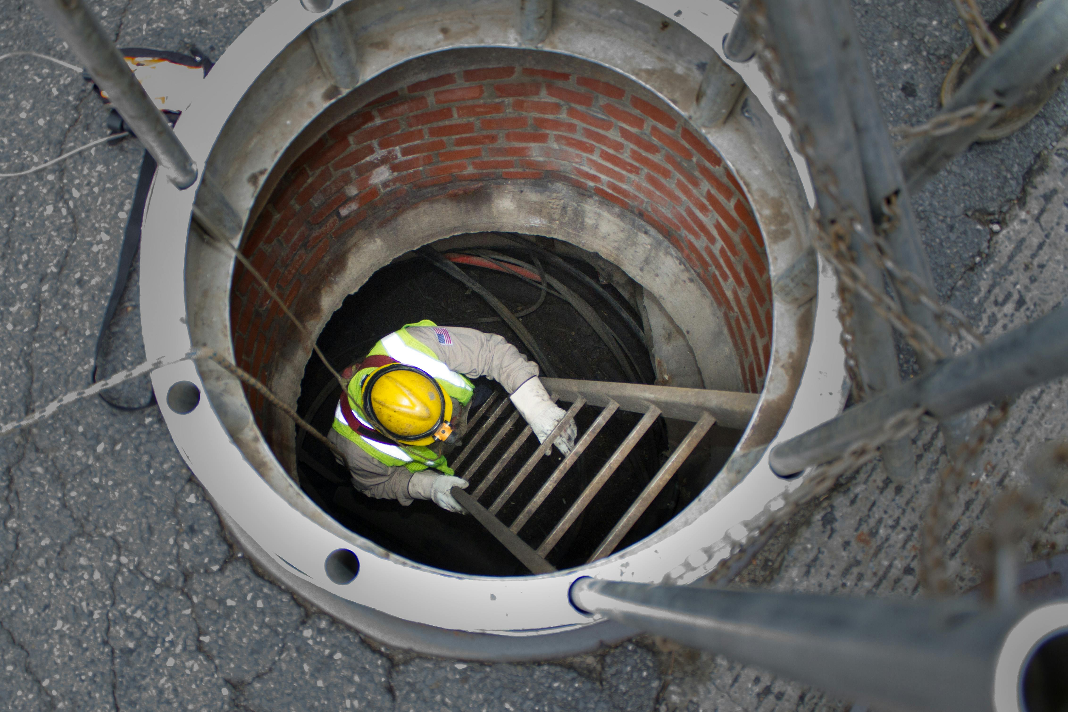 Underground worker enters underground electric vault.