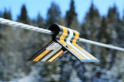 A bird diverter on a line during the day. The diverters were designed with the help of bird biologists to make sure they offer birds a visual cue to change their flight path from any angle, regardless of time of day or weather. A bird diverter on a line during the day. The diverters were designed with the help of bird biologists to make sure they offer birds a visual cue to change their flight path from any angle, regardless of time of day or weather.