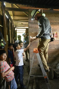 Billy Patterson prepares to screw in a light bulb to provide electricity to one of the homes in Guatemala. Billy Patterson prepares to screw in a light bulb to provide electricity to one of the homes in Guatemala.