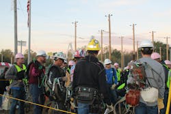 With their gear draped over their shoulder, the lineworkers get ready to compee at the Rodeo. With their gear draped over their shoulder, the lineworkers get ready to compee at the Rodeo.