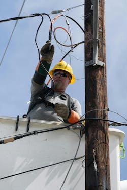 Cleco Power employee James Bergeron, power line technician III, connects underground service wire to an overhead service wire with a squeeze-on connector. Cleco Power employee James Bergeron, power line technician III, connects underground service wire to an overhead service wire with a squeeze-on connector.