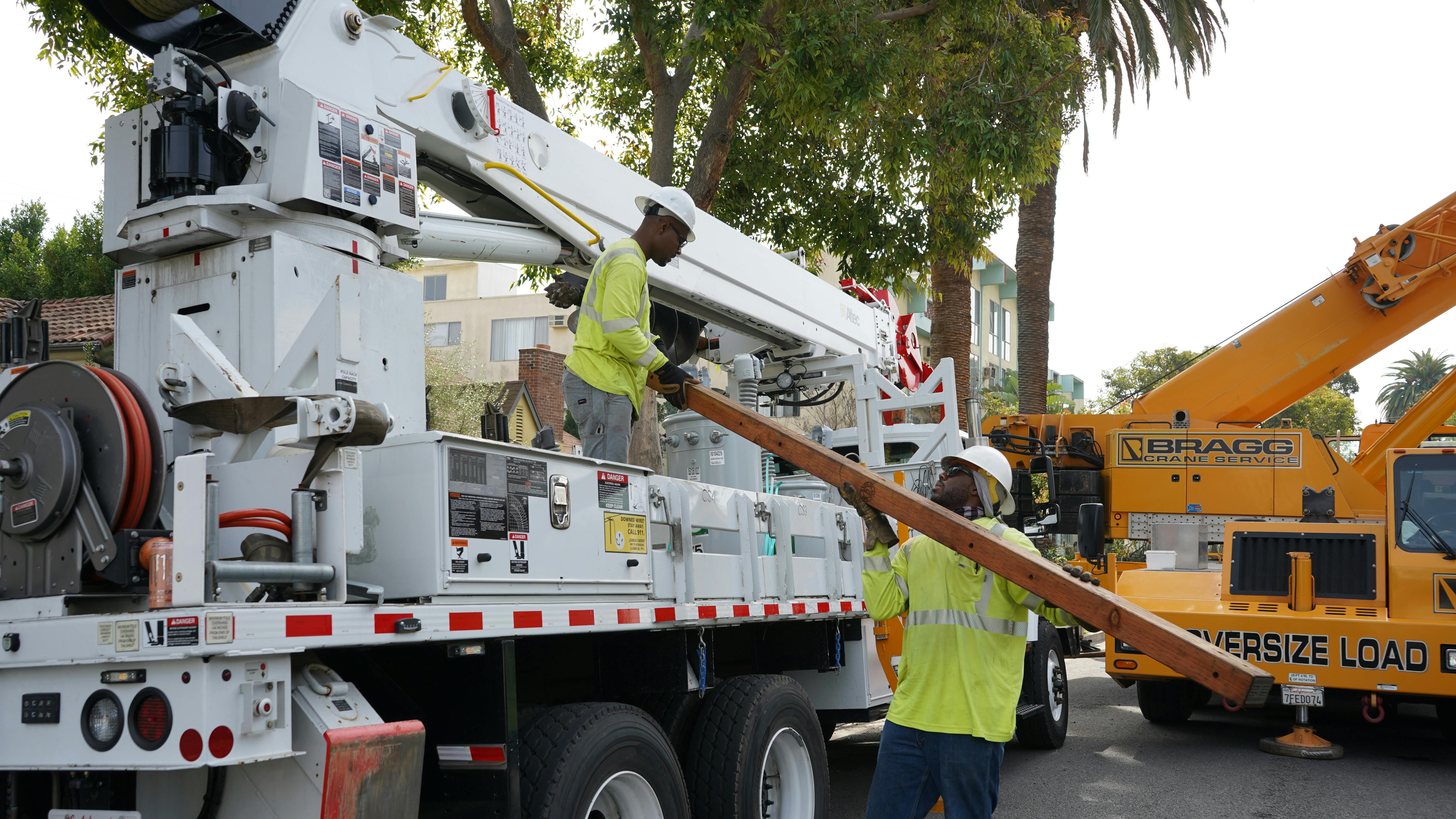 Donald Boyd (left), SCE groundman and 2023 Lineworker Scholarship recipient, and Nathan A. Griffith (right), SCE lineworker, prepare materials to build a crossarm in West Hollywood, California.