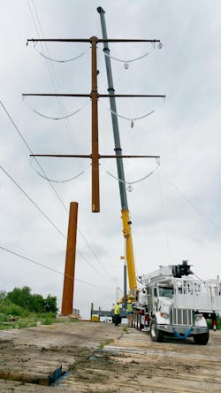 Crews setting top section of double circuit structure. Crews setting top section of double circuit structure.