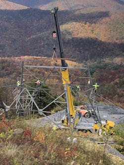 The line crew erects a pylon/tower on a mountainside. The line crew erects a pylon/tower on a mountainside.